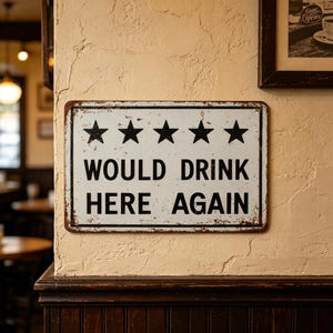 May include: A rectangular metal sign with a white background and a distressed finish. The sign features five black stars in a horizontal row above the black text that reads WOULD DRINK HERE AGAIN. The sign has a thin black border and rounded corners.