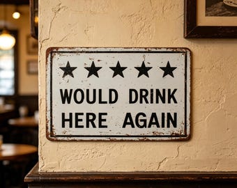 May include: A rectangular metal sign with a white background and a distressed finish. The sign features five black stars in a horizontal row above the black text that reads WOULD DRINK HERE AGAIN. The sign has a thin black border and rounded corners.