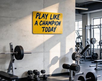 May include: A rectangular yellow metal sign mounted on a concrete wall with the dark blue text "PLAY LIKE A CHAMPION TODAY" printed in a bold, sans-serif font. The sign features small circular mounting holes in each of its four corners.