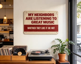 May include: A rectangular metal sign with a cream background and a red horizontal stripe. The text reads: MY NEIGHBORS ARE LISTENING TO GREAT MUSIC WHETHER THEY LIKE IT OR NOT. The sign features a distressed, weathered finish with rounded corners.