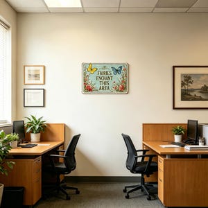 May include: A rectangular metal sign with the text "FAIRIES ENCHANT THIS AREA" in a vintage style. The sign features a yellow butterfly, a blue butterfly, and floral accents. The sign is mounted on a white wall in an office setting.