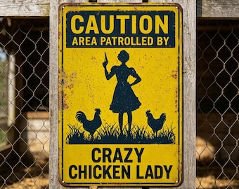 May include: A yellow metal sign with the text "CAUTION AREA PATROLLED BY" above a silhouette of a woman holding a gun, with two rooster silhouettes and the text "CRAZY CHICKEN LADY" below. The sign is mounted on a wooden fence.