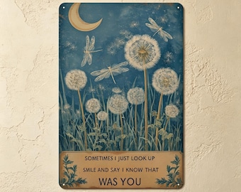 May include: A rectangular metal sign featuring a dark blue night sky with a crescent moon, white dandelion seed heads, and dragonflies. At the bottom, a tan rectangular box contains the text: SOMETIMES I JUST LOOK UP SMILE AND SAY I KNOW THAT WAS YOU.