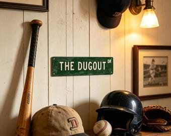 May include: A rectangular green metal street sign with white text reading THE DUGOUT DR, accompanied by a wooden baseball bat, a tan and black baseball cap, a black batting helmet, a baseball, and a brown leather baseball glove.
