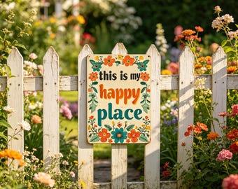 May include: A rectangular metal sign with the words "this is my happy place" in orange, teal, and green, surrounded by floral designs. The sign hangs on a white picket fence in a garden filled with colorful flowers.