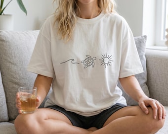 Camiseta minimalista con estampado de tortuga marina, olas y sol, camiseta gráfica veraniega sencilla con motivos costeros, top informal para amantes del océano y las vacaciones en la playa.