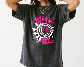 Camiseta vintage de Blink 182 estilo punk rock con grafiti y efecto desgastado, estilo retro de los 90, con estampado de cara sonriente de una banda de pop punk.
