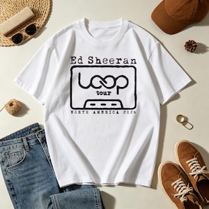 May include: A white short-sleeve t-shirt featuring a black graphic of a cassette tape with the text Ed Sheeran, Loop Tour, and North America 2026. The design is centered on the chest of the shirt, which has a crew neckline and a standard fit.