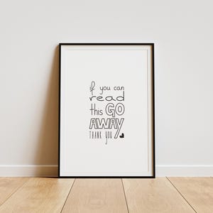 Może przedstawiać: Biały ceramiczny kubek z czarnym uchwytem i napisem "But First, Coffee" pogrubioną czcionką. Kubek jest ustawiony na rozmytym tle, sugerującym przytulne otoczenie.