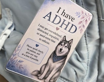 May include: A rectangular laminated tag with a jute string featuring a watercolour illustration of a husky wearing a blue bandana. The text reads: I have ADHD. I may get overwhelmed, distracted, impulsive, or need extra time to refocus. Please speak clearly, be patient, and give one step at a time if possible.