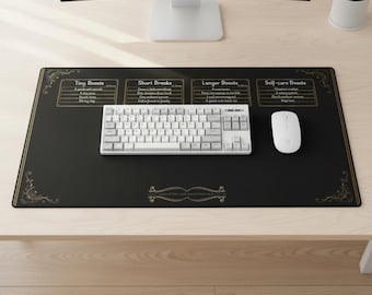 May include: A black desk mat featuring gold decorative corner flourishes and four text boxes labelled Tiny Boosts, Short Breaks, Longer Boosts, and Self-care Boosts. A white mechanical keyboard and a white computer mouse are placed on the mat.