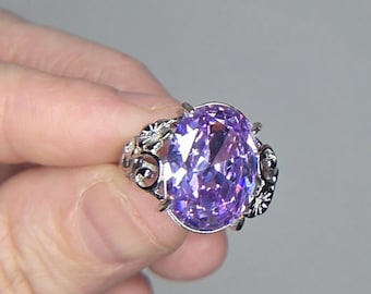 Anillo solitario ovalado de 12 x 16 mm con diamante cúbico color lavanda, banda ajustable de plata de ley y adornos florales.