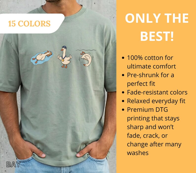 May include: Sage green t-shirt with a cartoon goose design. The shirt features three geese in different poses, with the text "15 COLORS" in a white box. The words "ONLY THE BEST!" are also visible.