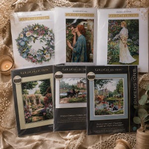 May include: A collection of Dimensions Gold Collection cross-stitch kits. The kits feature detailed, colorful designs, including floral wreaths, portraits, and landscape scenes. The kits are packaged in clear plastic with the Dimensions Gold Collection logo.