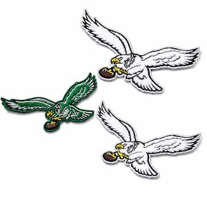 May include: Three embroidered patches featuring eagles in flight, each clutching a brown football in its talons. Two patches are white with yellow beaks and black outlines, while one patch is green with white wing details and a yellow beak.