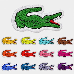 May include: Embroidered patches featuring a crocodile design in various colors, including green, yellow, blue, and red. The patches have a white border and are suitable for clothing or accessories.