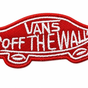 May include: A red embroidered patch shaped like a skateboard with white stitching. The text VANS is centered above the text OFF THE WALL, which is written in a stylized font across the center of the patch. The design features white outlines.