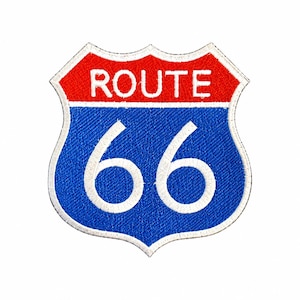 May include: A shield-shaped embroidered patch featuring the text ROUTE in white on a red background above the number 66 in white on a blue background, all outlined with a white border against a plain white background.