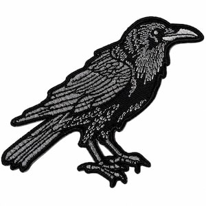 May include: A black and white embroidered patch featuring a detailed raven in profile. The bird is depicted with intricate white stitching that highlights its feathers, beak, and eye, set against a solid black background with a stitched border.