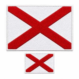 May include: Two embroidered patches featuring the Alabama state flag. The larger patch is rectangular with a white background and a prominent red X. The smaller patch mirrors the design. Both have a stitched border.