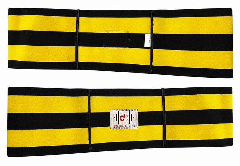 May include: A rectangular fitness belt featuring horizontal black and yellow stripes. The belt includes a white fabric patch in the center displaying the red and black text 'dk' above the words 'DRAGON FITNESS' and a small white care label tag.
