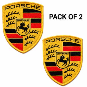 May include: Two embroidered Porsche patches. Each patch features the Porsche crest with the word "PORSCHE" at the top, and the city "STUTTGART" with a black horse in the center. The patches have a yellow background with red and black accents.