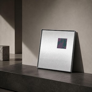Peut inclure: Une œuvre d'art murale carrée dotée d'un cadre en argent métallique et d'un fond argenté clair. Un petit encart rectangulaire est placé dans le quadrant supérieur droit, affichant un motif texturé de formes abstraites violet foncé et vert foncé.