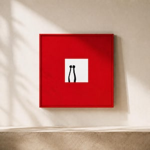 May include: A square wall art piece featuring a vibrant red frame and border surrounding a central white square. Inside the white square, two black, slender, vertical shapes with rounded tops are positioned side by side, resembling abstract legs.