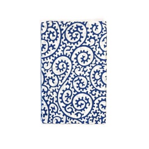 Peut inclure: Un tissu plié de forme rectangulaire, avec un fond blanc et un motif répétitif de formes bleues en spirale, ressemblant à des engrenages. Le motif est symétrique et couvre toute la surface.
