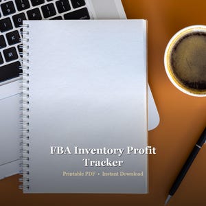 May include: A white spiral-bound notebook with blank pages, positioned next to a laptop keyboard and a cup of coffee. The notebook has the text "FBA Inventory Profit Tracker" printed on it, along with "Printable PDF • Instant Download". A black pen rests nearby.