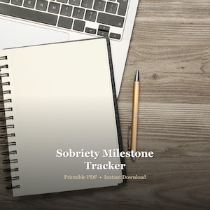 May include: A spiral-bound notebook with the text "Sobriety Milestone Tracker" and the words "Printable PDF • Instant Download" is placed on a wooden surface next to a laptop and a gold pen.