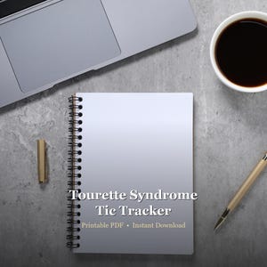 May include: A spiral-bound notebook with the text "Tourette Syndrome Tic Tracker" is centered on a gray surface. A gold pen and a cup of coffee are on the right. A laptop is in the upper left corner. The notebook also says "Printable PDF • Instant Download".