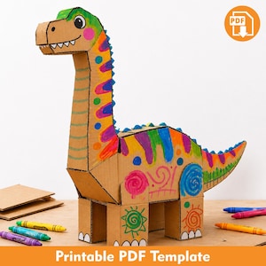 Puede incluir: Una figura de dinosaurio tridimensional construida con cartón marrón, con patrones coloridos dibujados a mano en rosa, azul, verde y naranja. El dinosaurio tiene un cuello largo, una cola y cuatro patas, con un icono de PDF en la esquina.