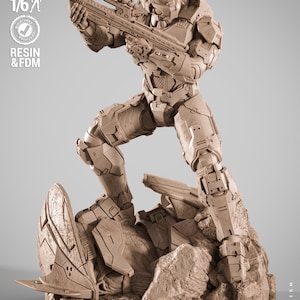 May include: A tan resin statue of a futuristic soldier in combat stance, holding a rifle. The figure is on a rocky base with the text "PRESUPPORTED TESTED SCALE 1/6 RESIN & FDM". The statue is from the "NEXT TERM" collection by "WICKED".
