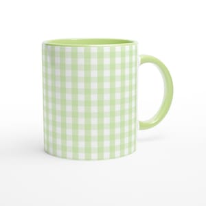 May include: A ceramic mug with a light green gingham pattern. The interior and handle are also light green. The mug is a classic coffee cup shape, perfect for hot beverages. The mug is set against a white background.