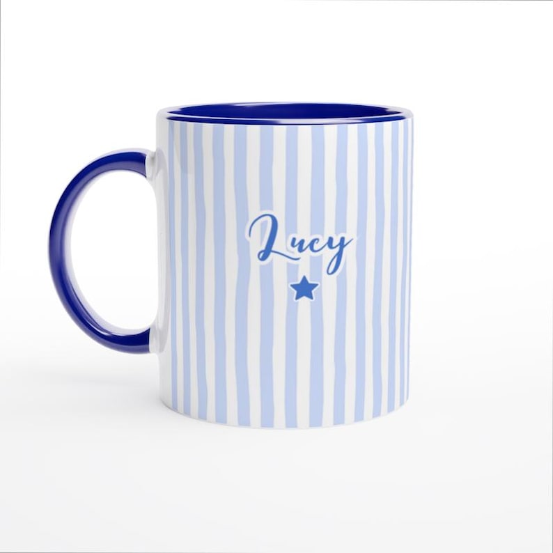 May include: A white ceramic mug with a black handle and the text "But First, Coffee" in a bold, black font. The mug is set against a blurred background, suggesting a cozy setting. The mug appears to be approximately 4 inches tall.