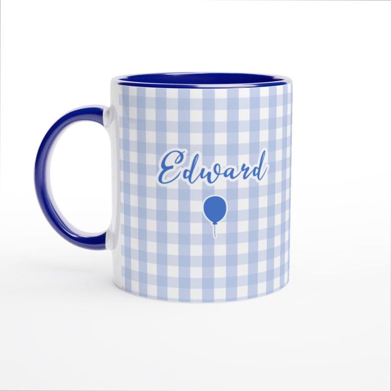 May include: A white ceramic mug with a blue interior and handle. The mug features a light blue and white gingham pattern. The name "Edward" is written in cursive, with a blue balloon graphic below.