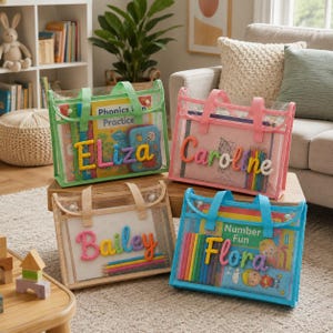 May include: Four rectangular clear plastic tote bags with fabric handles, each personalized with a colorful yarn-stitched name: Eliza, Caroline, Bailey, and Flora. The bags contain various children's books, colored pencils, and activity supplies.