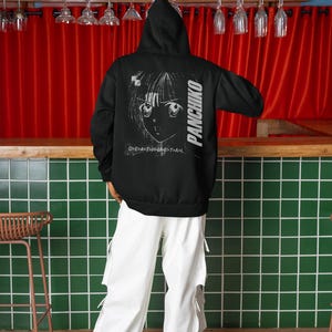 Studio fashion shot of a model wearing a white tee, front print preview featuring Panchiko deathmetal album.