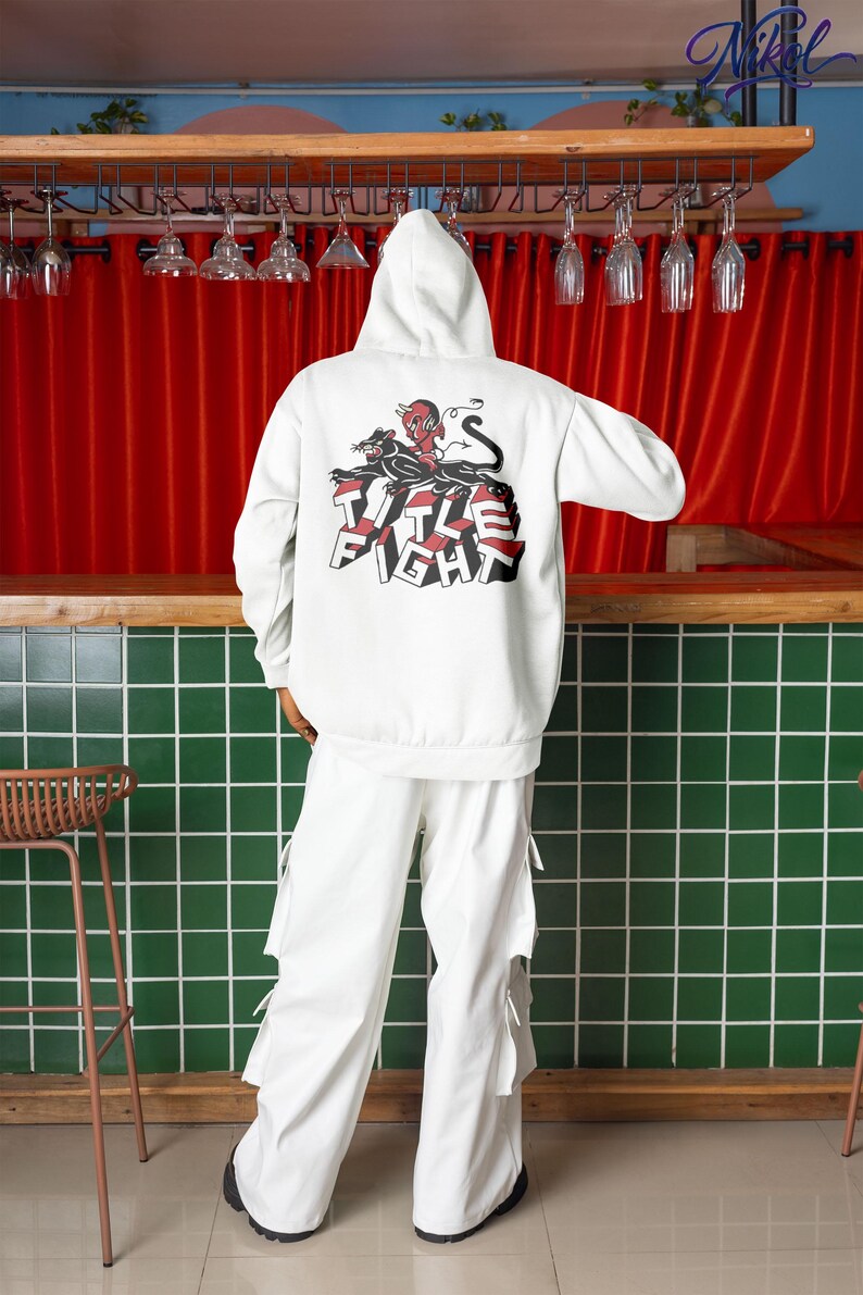 Back view white pullover hoodie worn in an indoor setting, featuring Title Fight centered on the back.