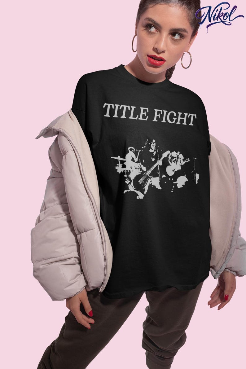 Lifestyle photo of a model wearing an oversized white t-shirt with Title Fight printed on the front.