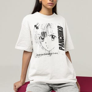 Studio lifestyle shot of a white oversized tee on a model, front print featuring panchiko deathmetal album.