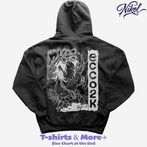 May include: Black hooded sweatshirt with a white graphic on the back. The graphic features a stylized illustration of a person with long hair, chains, and the text "2002". The sweatshirt also has the text "T-shirts & More" at the bottom.