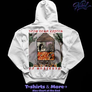 Op de afbeelding: Een witte hoodie met een afbeelding op de achterkant. De afbeelding toont een huis met figuren en vlammen, met de tekst "LONG TERM EFFECTS OF SUFFERIN". De hoodie heeft ook de tekst "T-shirts & More" en een link naar de maattabel.