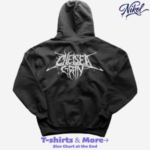 Pode incluir: Um moletom preto com o nome da banda "Chelsea Grin" em letras brancas estilizadas nas costas. O moletom também apresenta o texto "T-shirts & More" e "Size Chart at the End" em roxo. Uma assinatura no canto superior direito.