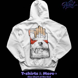 May include: White hoodie with a cigarette pack graphic, the text "SUICIDEBOYS", and a skull design. The hoodie also has the text "T-shirts & More" at the bottom.