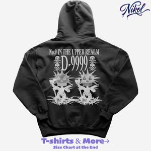Puede incluir: Sudadera con capucha negra con un diseño gráfico blanco en la espalda. El diseño incluye el texto "No.9 IN THE UPPER REALM D-9999" y dos figuras estilizadas con caras de calavera. La parte inferior de la sudadera tiene el texto "T-shirts & More→ Size Chart at the End".
