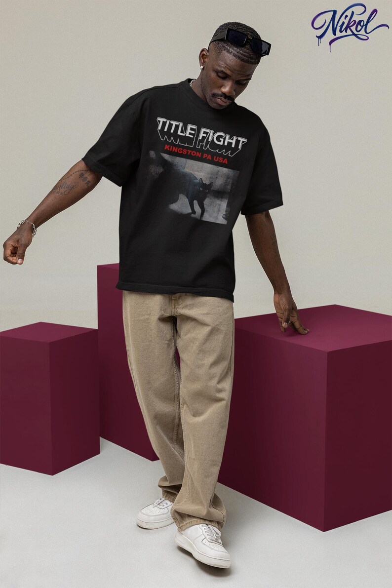 Outdoor lifestyle shot of a white unisex t-shirt, front print featuring Title Fight on the chest area.