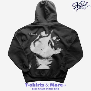 May include: Dark gray hoodie with a hood and a white graphic on the back. The graphic is a stylized image with the text "ballads 1" above it. The hoodie also has the text "T-shirts & More" at the bottom.