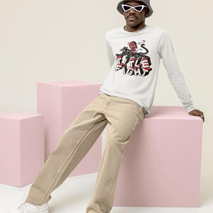 Lifestyle mockup of a white long-sleeve shirt in a relaxed pose, featuring title fight clearly.